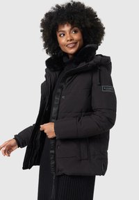 Black puffer jacket with a faux fur-lined hood, zipper and button closures, side pockets, and a logo patch on the sleeve.