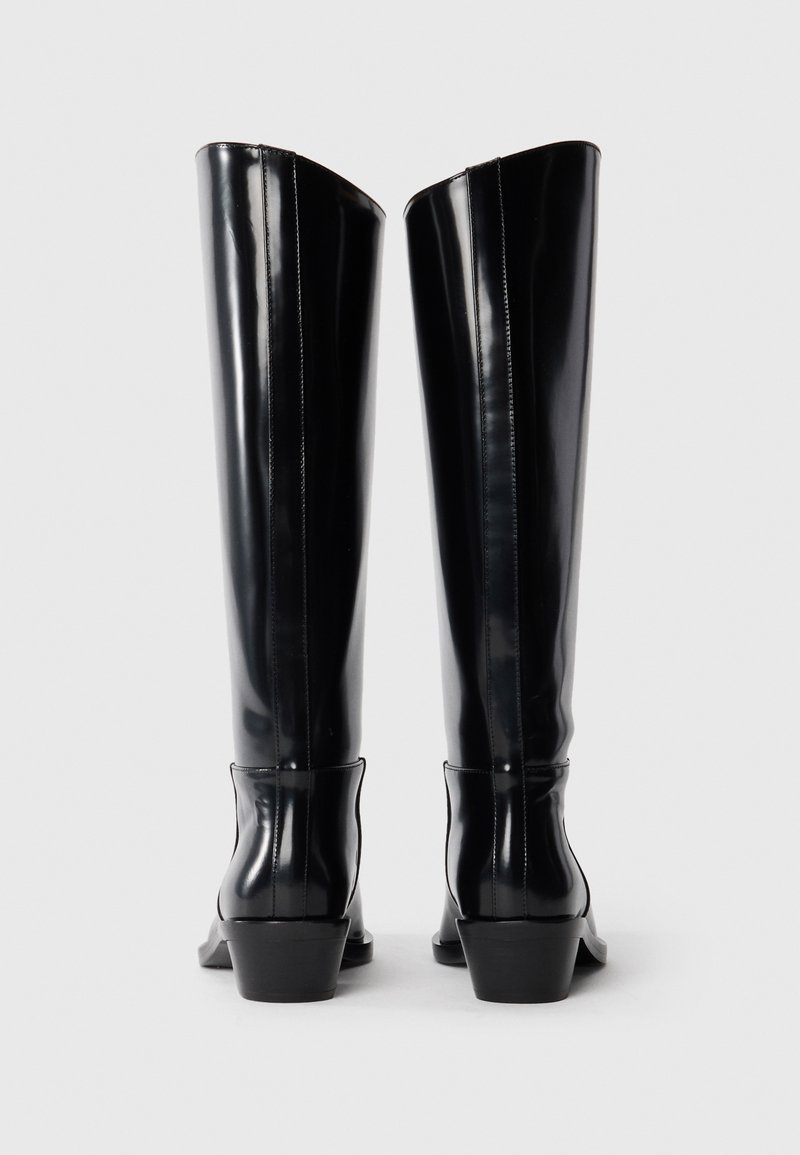 Schwarze kniehohe Stiefel aus glänzendem Material mit spitzer Zehenform und Blockabsatz. Sie zeichnen sich durch elegante, gerade Linien und minimalistische Nähte aus.