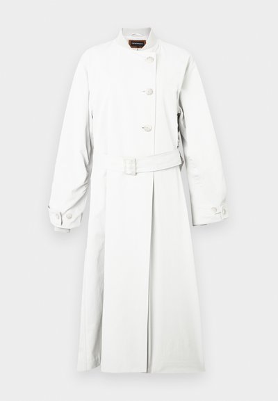 Fehér ballonkabát magas gallérral, hosszú ujjal és öves derékkal. Három feltűnő gombbal és sima, matt felülettel rendelkezik.