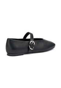 Zapato plano de cuero negro con punta afilada, tira en el tobillo y detalle de hebilla plateada. Diseño de tacón bajo y textura suave.