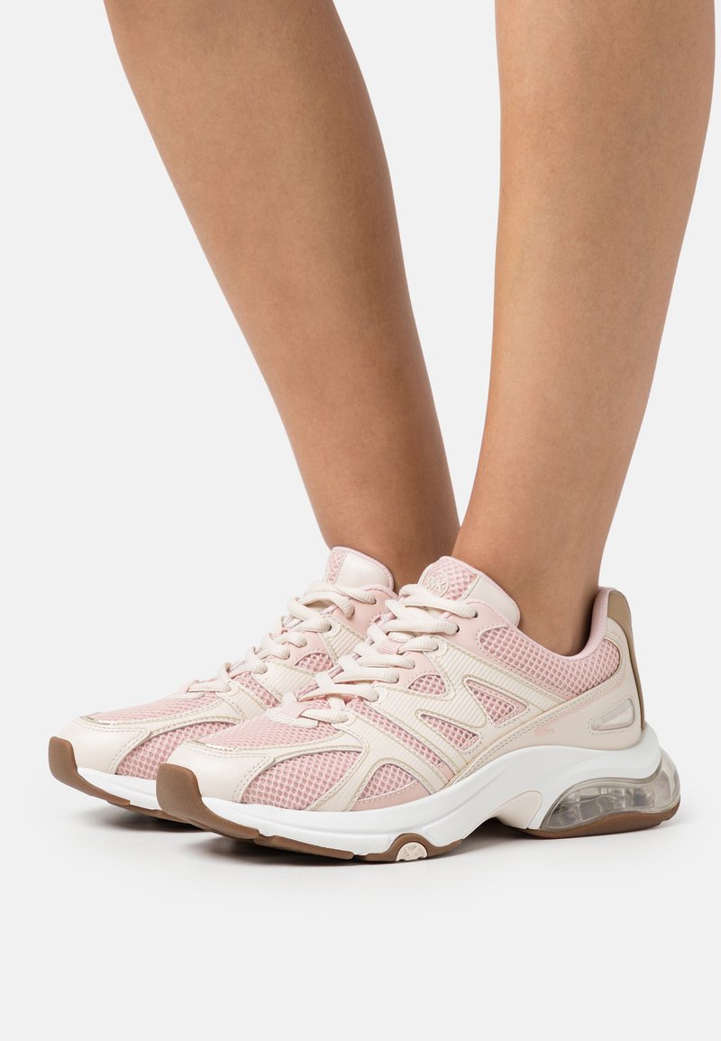 Sneaker atletiche in rete rosa chiaro con un design strutturato, dettagli bianchi, suola ammortizzata e particolare traslucido nel tallone.