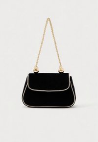 Crna torba od brušene kože sa zlatnim lancem kao remenom, s preklopnim zatvaračem i bijelim obrubom duž rubova za kontrast.