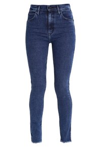 Jeans ajustados de talle alto en denim azul oscuro con un lavado desgastado, que presentan un dobladillo sin terminar y un clásico diseño de cinco bolsillos.