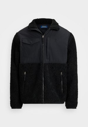 Svart zip-up fleecejacka med texturerad tyg, två framfickor med dragkedja, en bröstficka med klaff och ståkrage.