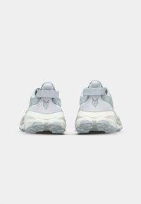 Sport shoes featuring a light blue and white mesh upper, padded collar, and textured outsole for traction. Back view shows logo detail.