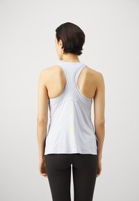 Hellblau-lila Sporttanktop mit Racerback-Design, versehen mit einem gedruckten Logo in Neongrün entlang des Rückens. Glattes, dehnbares Material.
