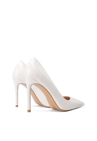 Alti tacchi in vernice bianca con punta affilata e tacco a stiletto alto, caratterizzati da una finitura liscia e lucida e una suola beige.