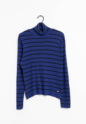 Pull à col roulé côtelé bleu avec des rayures horizontales noires suspendu à un cintre noir sur fond blanc.