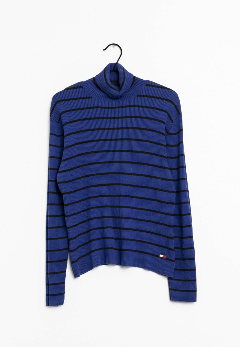 Pull à col roulé côtelé bleu avec des rayures horizontales noires suspendu à un cintre noir sur fond blanc.