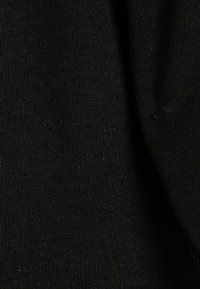 Schwarzer Baumwollstoff mit einer glatten, leicht dehnbaren Textur. Verfügt über eine gleichmäßige Oberfläche ohne sichtbare Muster oder Akzente.