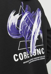 Felpa nera con un grande motivo di pennellata in viola e bianco, arricchita da forme geometriche e la scritta "CORECONC" in bianco bold.