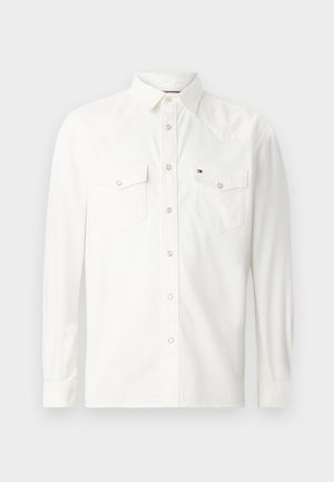 Vit långärmad skjorta i bomull, med två bröstfickor med knappflik, klassisk krage och knappstängning fram.