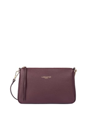 Pochette bracelet en cuir violet foncé avec fermeture éclair dorée et logo Lancaster Paris centré sur le devant.