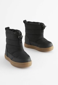 Bottes rembourrées noires avec un haut tige, dotées d'une fermeture par cordon au sommet et d'une semelle en caoutchouc marron contrastée. Matériau supérieur texturé.