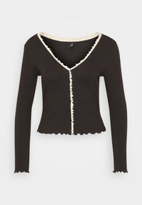 Black ribbed long-sleeve cardigan with a V-neck, cream ruffled trim, and a straight hem, featuring decorative dark buttons down the front.