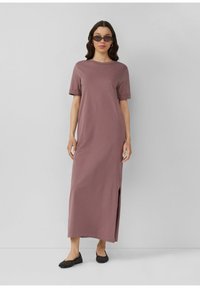 Mauve maksi haljina s kratkim rukavima, s bočnim prorezom. Izrađena od mekanog materijala, ima opušteni kroj i minimalistički dizajn.