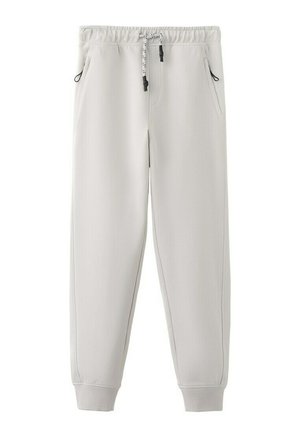 Pantalon de survêtement gris clair avec taille élastique, cordon de serrage noir et blanc, poches latérales et poignets côtelés.
