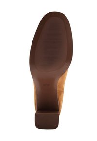 Suola di scarpa in suede marrone con fondo in gomma testurizzata. Presenta un tacco largo e contorni morbidi, contrassegnata con "MNG" vicino al tacco.
