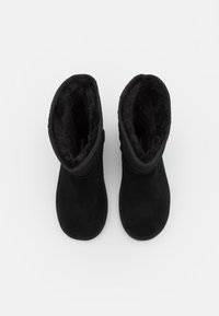 Black suede ankle boots with a soft, dark fur lining and rounded toe. Features a stitched seam and flat rubber sole.