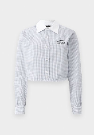 Mėlynai ir baltai languota trumpa marškinėlių palaidinė su balta apykakle. Ant jos siuvinėti žodžiai "MARCO JACOBS MARŠKINIAI".