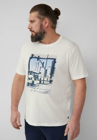 White cotton t-shirt featuring a blue graphic print of an urban scene with traffic signals and an auto rickshaw. Short sleeves and round neck.