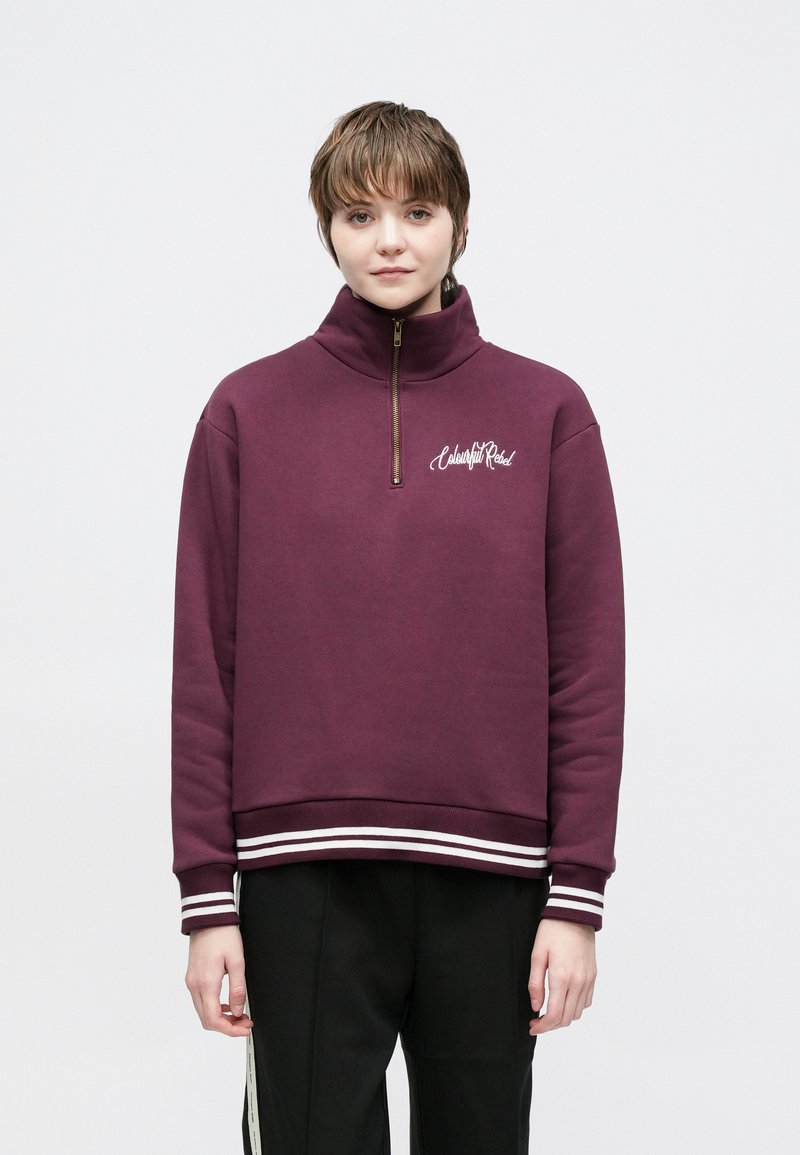 Bordeauxrode zip-up trui van een katoenmix, met een hoge kraag, witte gestreepte accenten aan de onderkant en geborduurd logo op de borst.