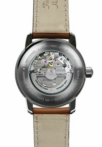 Automatische Armbanduhr mit Edelstahlgehäuse, transparentem Rückteil und beigem Lederarmband. Sichtbare Uhrwerksmechanik mit Zahnrädern und lila Akzenten.