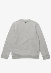 Grå sweatshirt med ribbad krage och mudd. Ikonisk grön logotyp broderad på den övre ryggen. Mjukt, texturerat tyg. Klassisk passform.