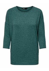 Teal oversized T-shirt made of soft, textured fabric. Features a round neckline and three-quarter sleeves, with a relaxed fit. No patterns or accents.