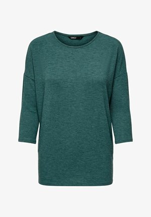 T-shirt oversized teal realizzato in un tessuto morbido e testurizzato. Presenta un collo rotondo e maniche a tre quarti, con una vestibilità rilassata. Nessun motivo o accento.