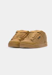 Tan skate shoes with textured suede and leather upper, round toe, flat laces, and logo accents on the side and tongue.