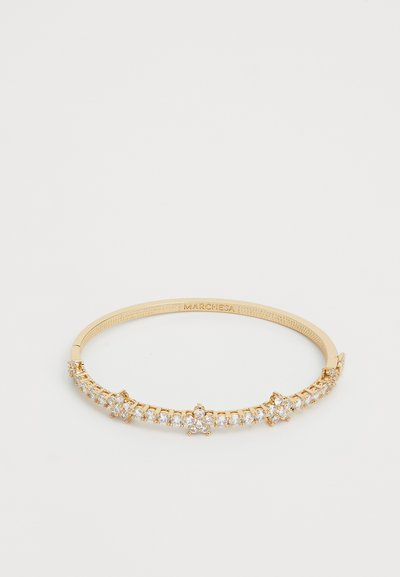 Gold-tone bracelet featuring a symmetrical design with clear, sparkling stones set in a pronged setting, showcasing fine craftsmanship.