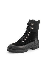 Zwarte veterschoen voor de winter met dikke zool, faux bont voering, metalen oogjes en leren accenten op witte achtergrond.