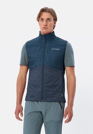Gilet isolante blu navy con colletto alto, chiusura con cerniera e dettaglio del logo. Presenta un design leggero e imbottito con tasche laterali.