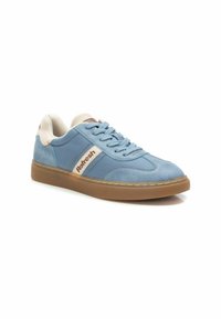 Zapatillas deportivas azules hechas de materiales lisos y de ante, con un talón de color crema y una suela de goma con un patrón texturizado.