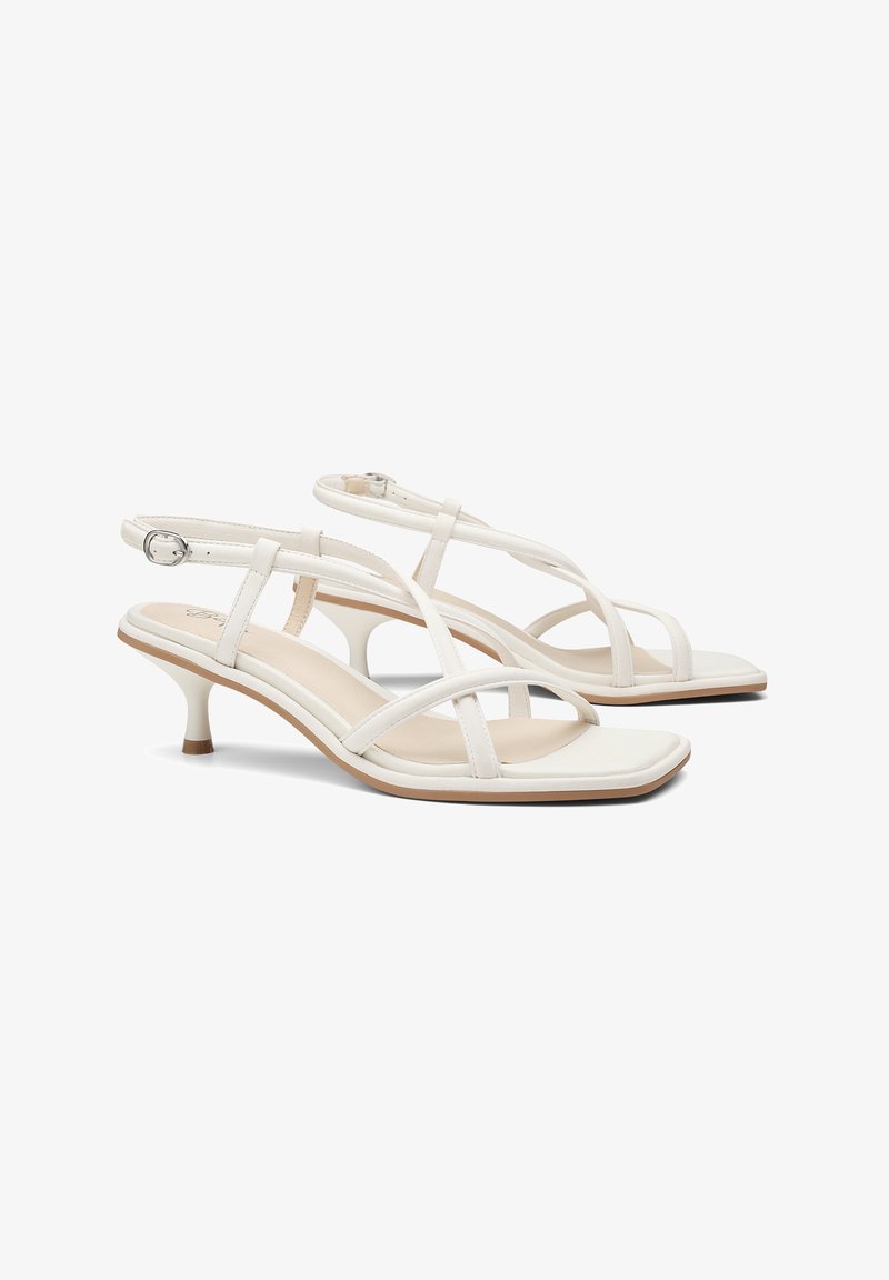 Sandalias de tacón blancas con diseño de puntera cuadrada, correas delgadas, hebilla ajustable en el tobillo y un tacón bajo con una base contrastante.