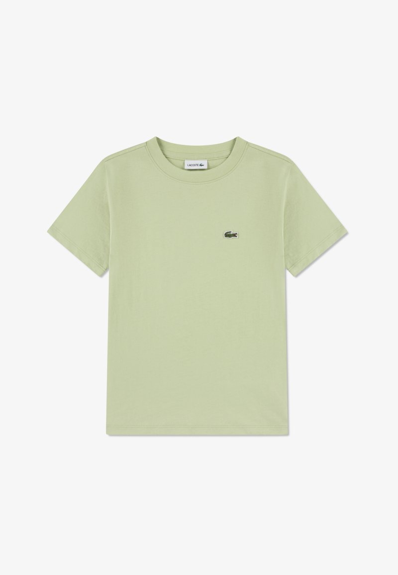 Camiseta de algodón verde claro con cuello redondo, mangas cortas y un pequeño logo de Lacoste en la parte superior izquierda del pecho. Textura suave.