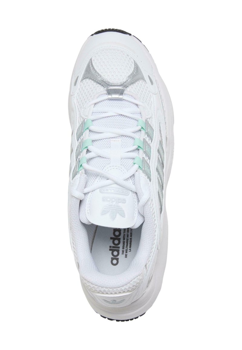 Witte sportschoen met een bovenwerk van mesh en synthetisch materiaal, zilveren accenten en een licht aqua tong. Voorzien van veters en een gevoerde zool voor ondersteuning.