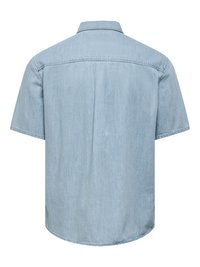 Vue arrière d'une chemise en jean bleu clair à manches courtes, avec un col et une couture centrale dans le dos.