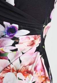 Klänning med svart ovandel och ett blommönster med rosa, vita och lila blommor. Plisserad tygdetalj vid midjan. Mjuk textur.