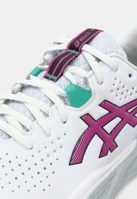 Valge sportlik jalanõu võrkmaterjalist pealsega, lilla ja türkiissiniste detailidega, tekstureeritud kummist tallaga, iseloomulike õhukestega ja julge logodega.
