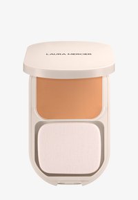 Polvo compacto de maquillaje con tapa beige etiquetada "Laura Mercier", que contiene polvo color marrón y una esponja aplicadora rectangular blanca en su interior.