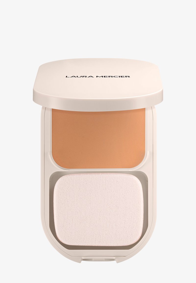 Polvo compacto de maquillaje con tapa beige etiquetada "Laura Mercier", que contiene polvo color marrón y una esponja aplicadora rectangular blanca en su interior.