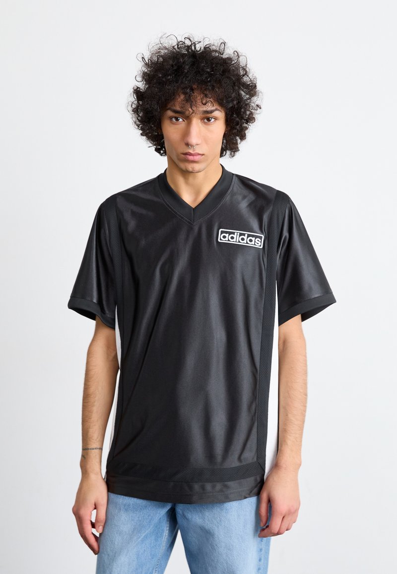 Camisola desportiva preta da Adidas com decote em V, mangas curtas e um logo branco no peito esquerdo; textura suave com um corte descontraído.