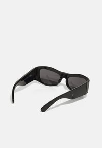 Lunettes de soleil noires avec une finition lisse et brillante. Verres rectangulaires avec une teinte foncée. Monture courbée et épaisse avec des branches droites et fines.