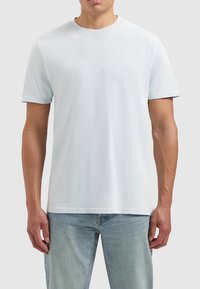 Lichtblauwe katoenen t-shirt met korte mouwen, ronde hals en een gladde textuur. Eenvoudig ontwerp, geen zichtbare patronen of accenten.
