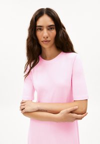 Short-sleeve pink cotton dress with a round neckline. Features a relaxed fit and visible seam detailing on the front.