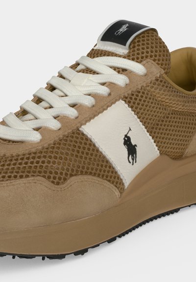 Baskets en mesh et daim marron clair avec lacets blancs, panneau latéral blanc, logo joueur de polo noir et semelle marron rembourrée.