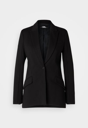 Czarna marynarka o zdefiniowanej konstrukcji, z klapami w kształcie notcha, pojedynczym zapięciem na guzik, dwoma kieszeniami bocznymi oraz gładką fakturą materiału.