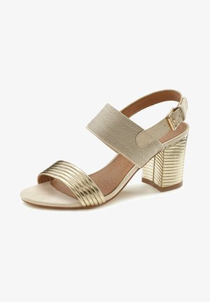 Gouden sandalen met hakken, voorzien van een gestructureerde visgraatband, een brede metalen band en een ribbelachtige blokhak. Open teen design.